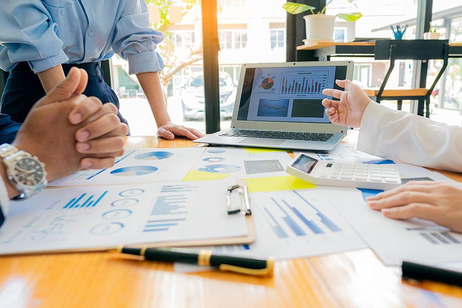 Marketing professional at a meeting looking at marketing charts on their computer.